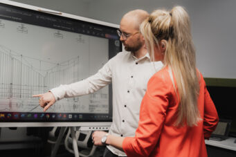 Deux collaborateurs Cteam analysent des plans techniques sur un écran interactif. Deux collaborateurs Cteam analysent des plans techniques sur un écran interactif.